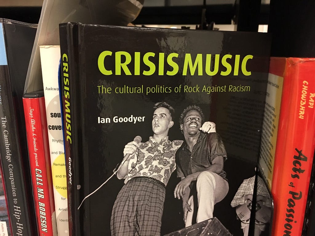 Photograph of some of the book stock at the Ahmed Iqbal Ullah RACE Centre. Featured prominently is a book with the title Crisis Music: the cultural politics of rock against racism.