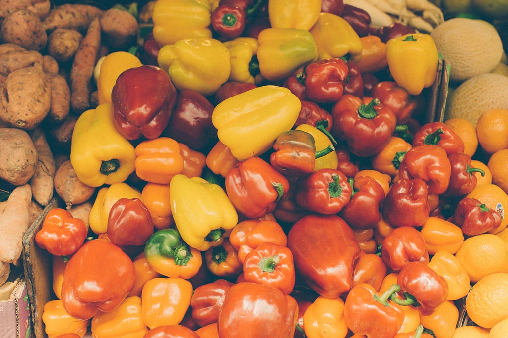 Bell peppers of different shapes and sizes, and hues of orange