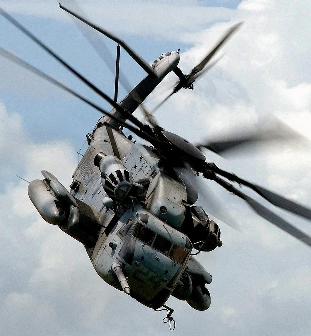 grey helicopter in cloudy sky with helicopter blades in motion; posted on 2024 mickey markoff article on aviation history month