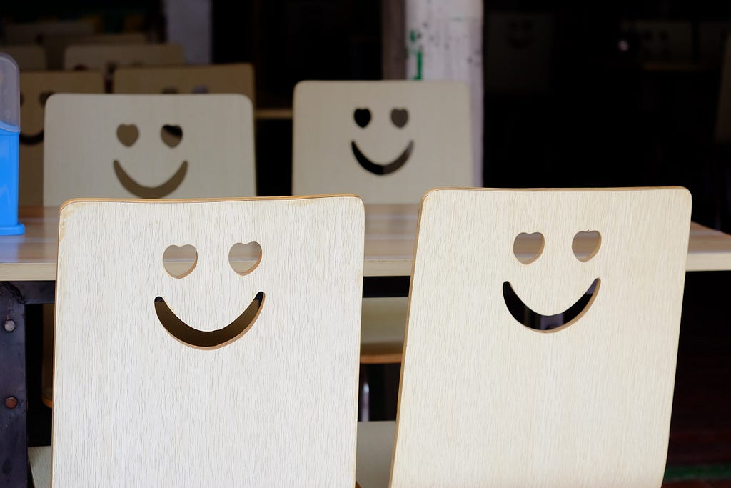a photo of wooden cards showing happy faces