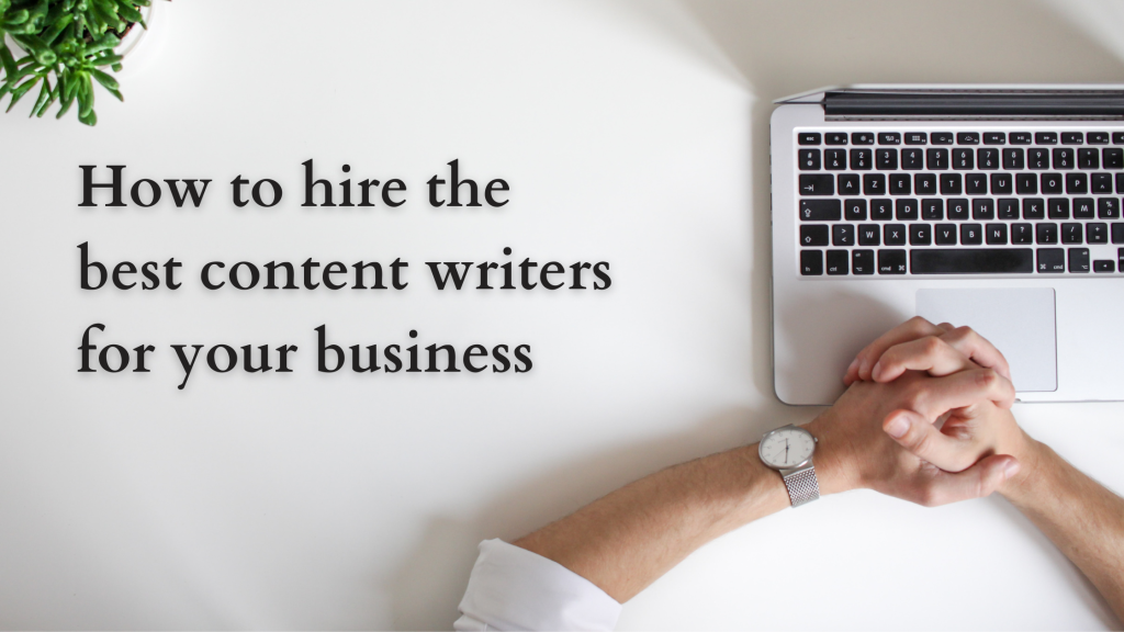 The picture shows the topview of a laptop sitting open on a table. A person’s hands are resting on the table and on the top left corner, we can see a small green plant. The right side of the image shows the text “How to hire the best content writers for your business”