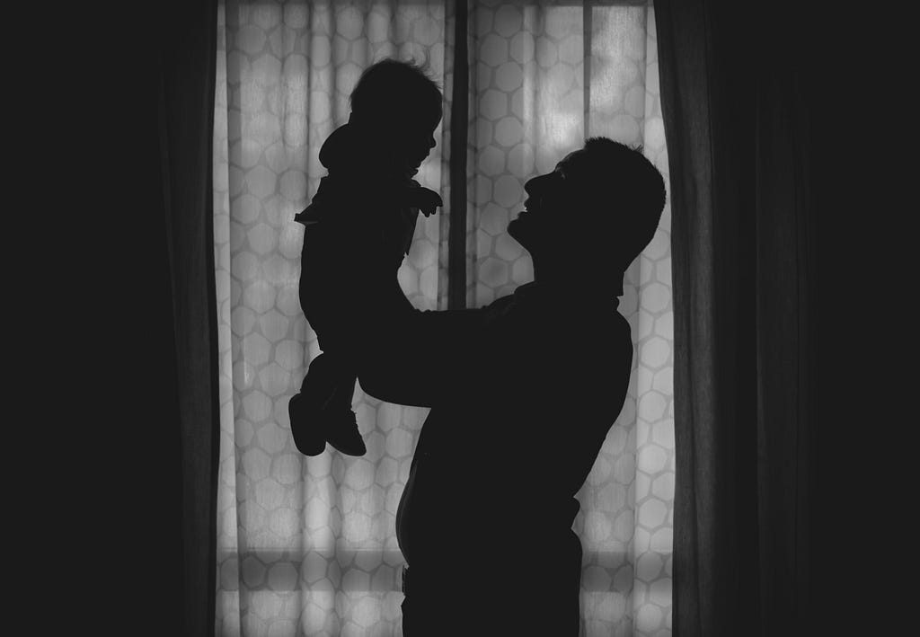 Father is holding his daughter, singing a folk song.