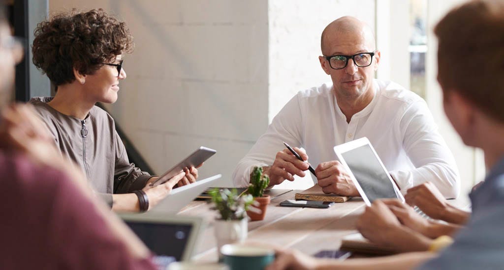 CEO leading team of employees in group discussion