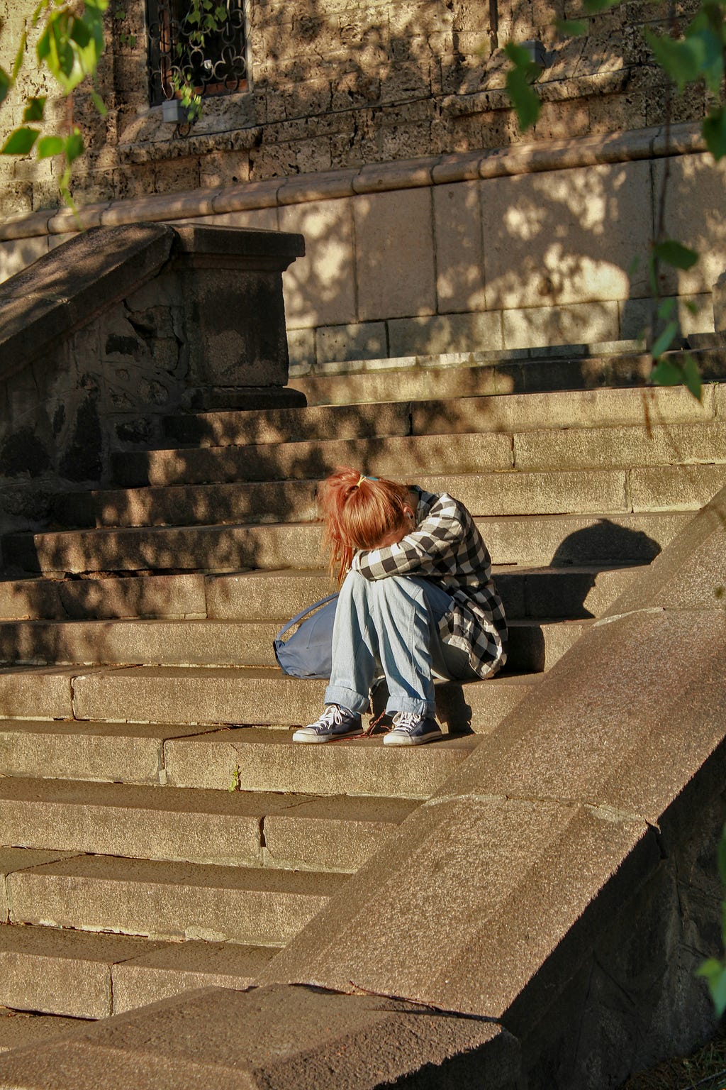 A kid sitting on a stair case crying