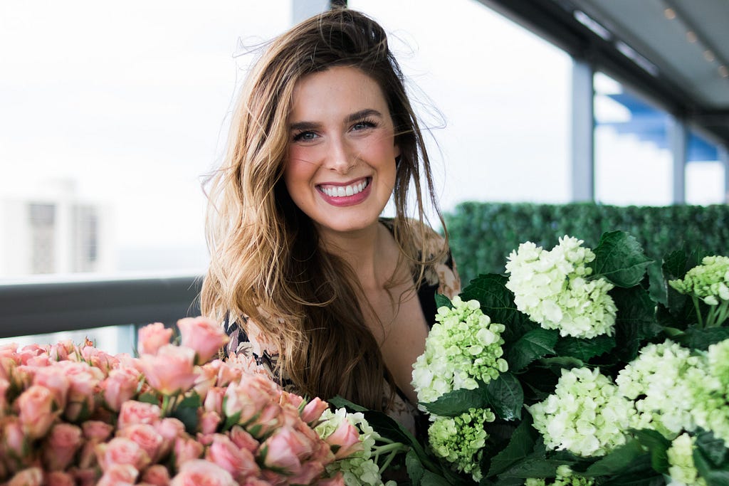 pretty woman smiling with floral display