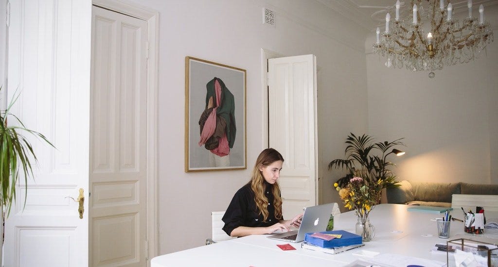 Virtual assistant sitting at her desk and working on a laptop