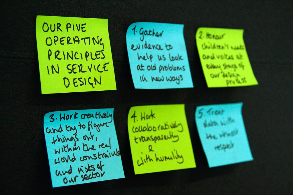 The five principles of the service design team written out on post - it notes