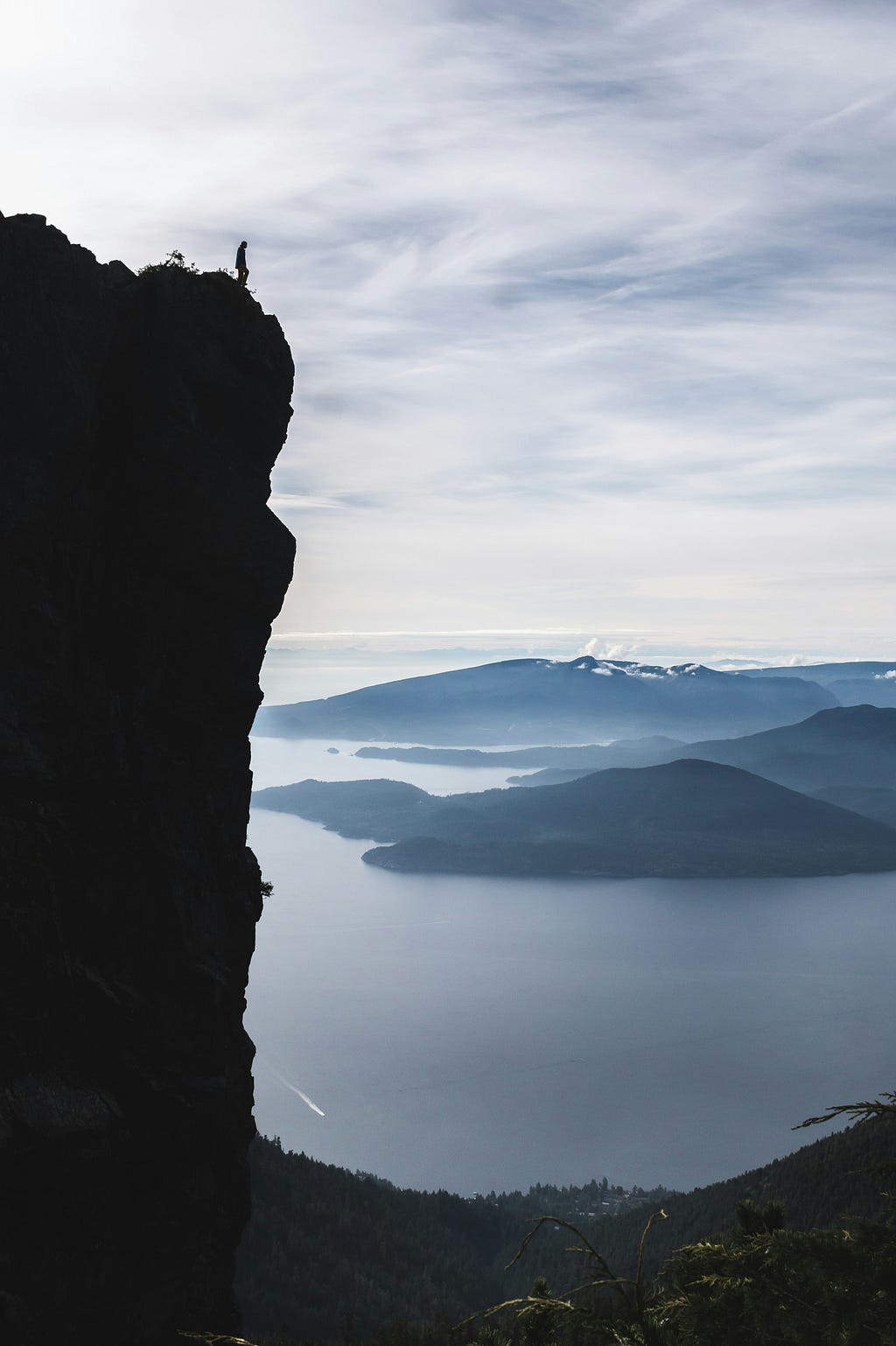 man looking at beautiful landscape from edge of cliff