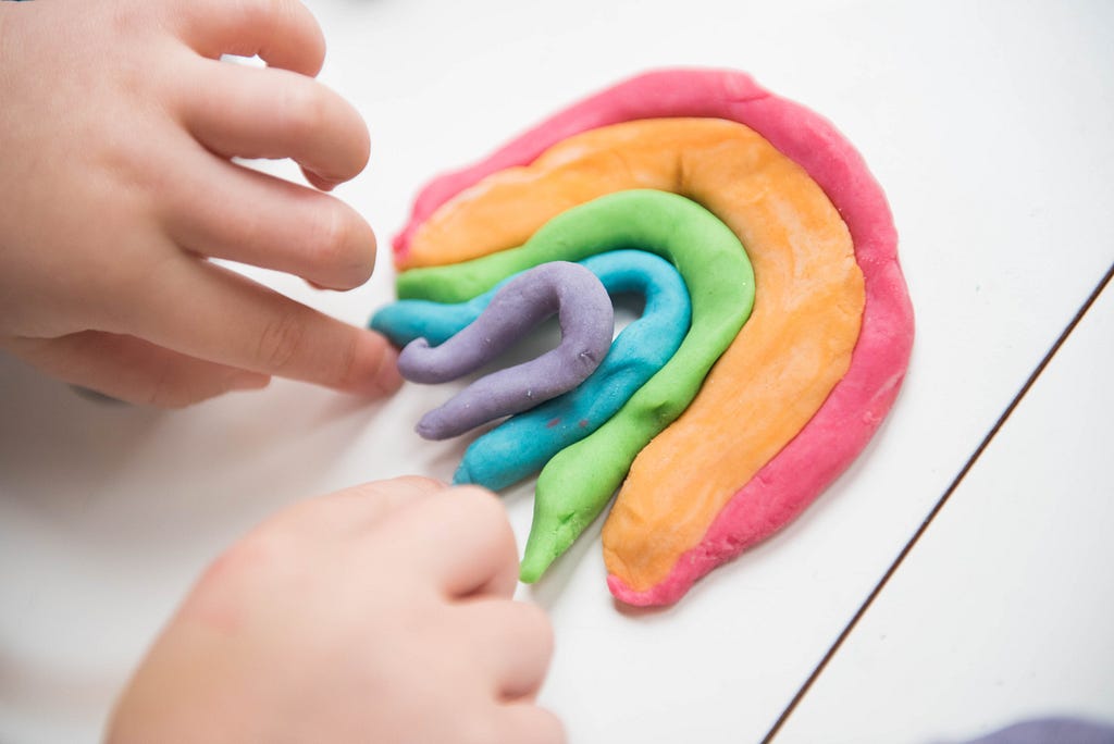A child making a rainbow from playdough