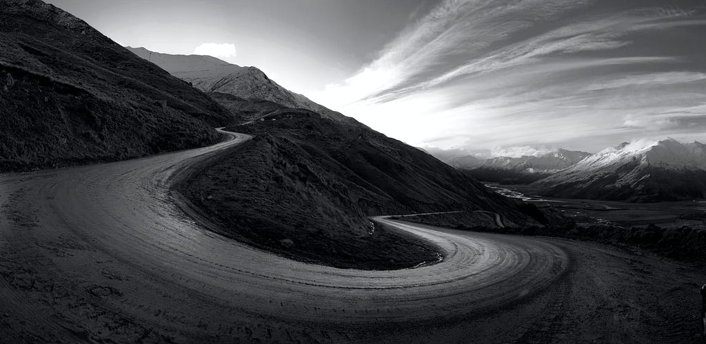 A curvy mountain road, twisting around a mountain.