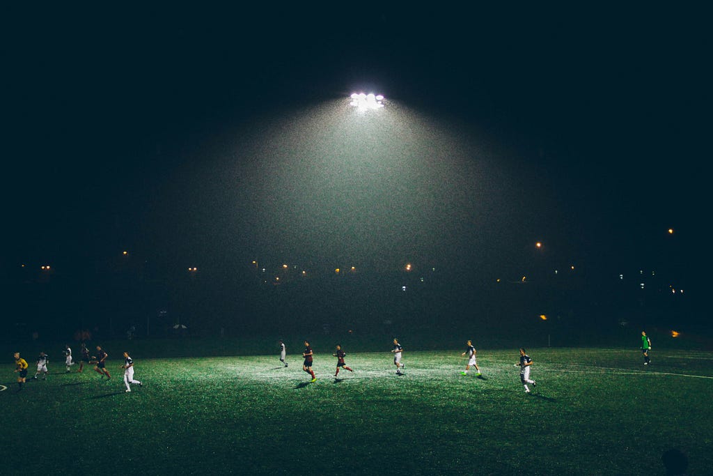 Photo of a soccer team playing against another team on a field