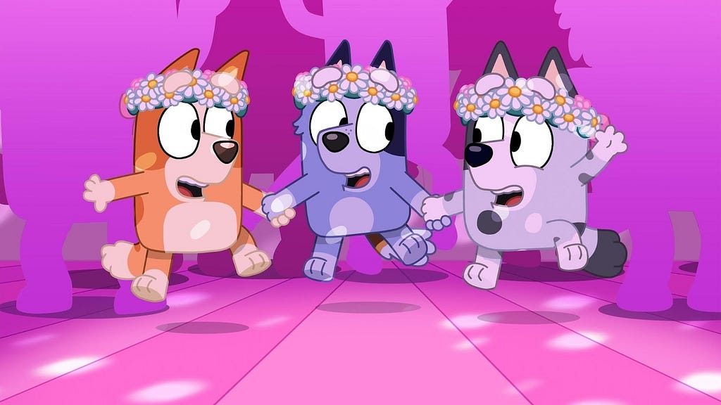 Cartoon image of orange dog, blue dog, and gray dog toddlers dancing in flower crowns, from the show Bluey.