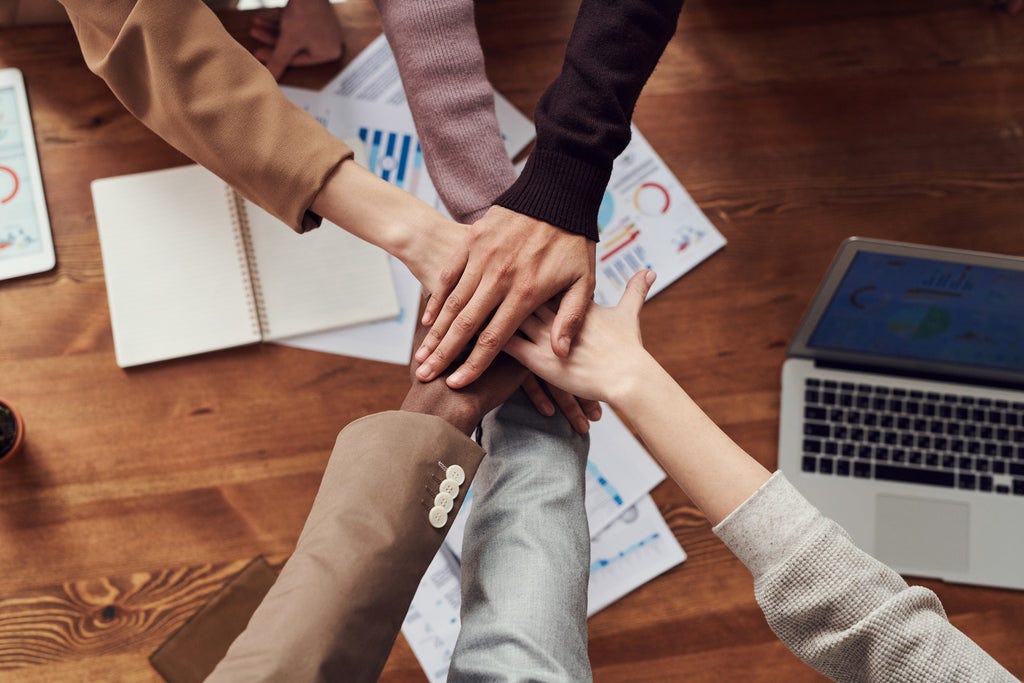 a team with hands together to signify team-work.