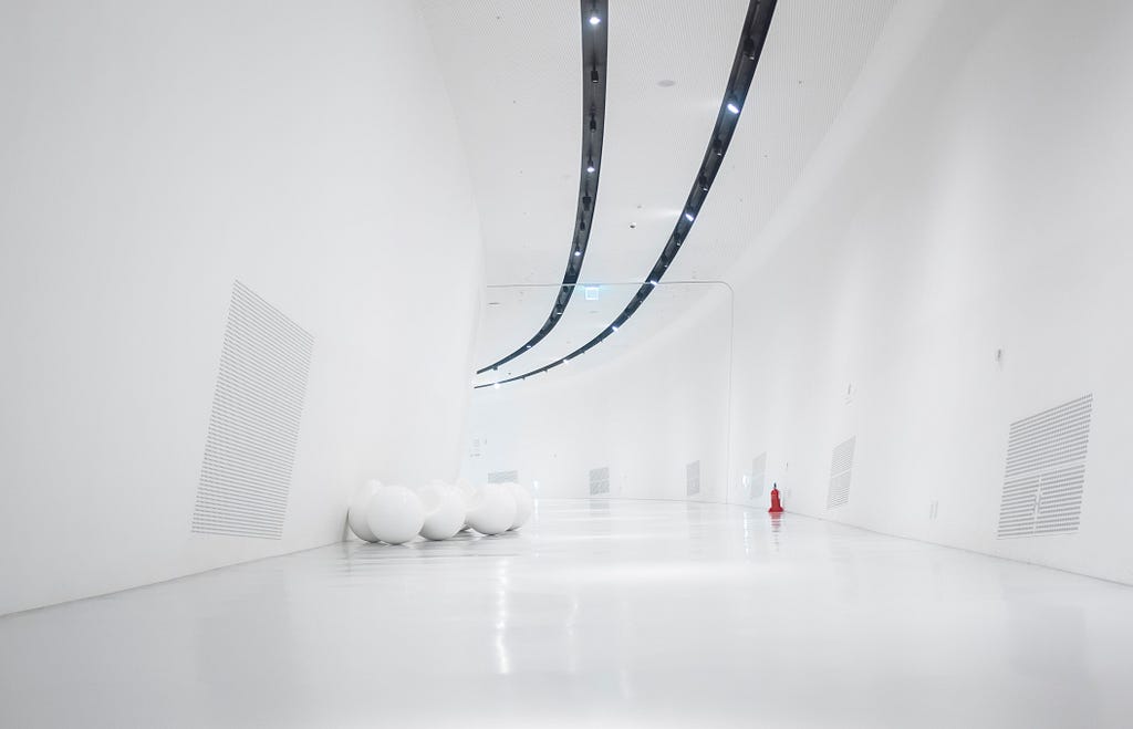 “A long horizontal space of white walls and runner lights.”