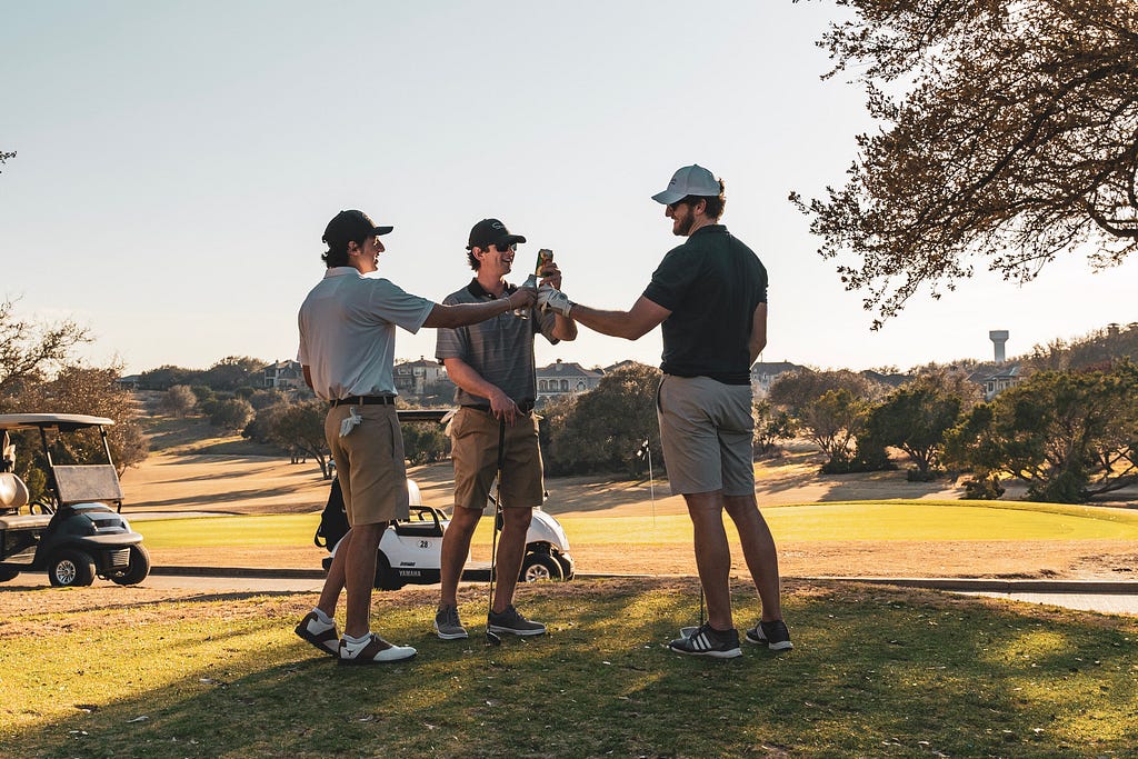 Three guys cheersing after a round of golf.