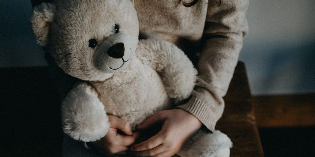 Girl holding bear by Annie Spratt on unsplash