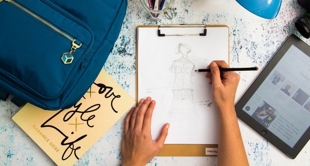 Person sketching a design for a dress