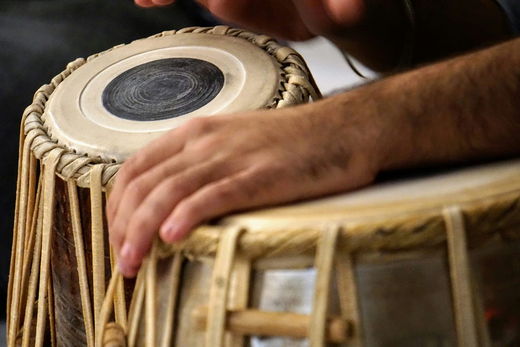 close up color photograph of person playing the djeme drums