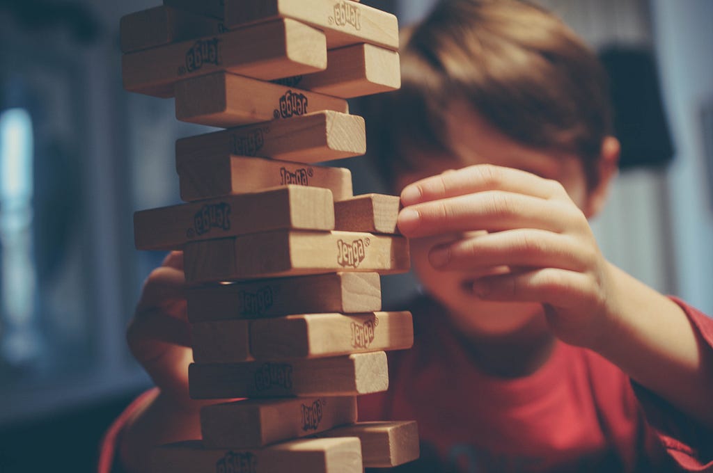 A kid playing the game Jenga