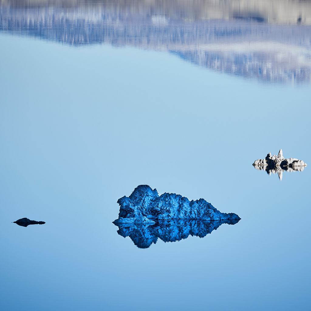 Reflections of rocks in a calm lake.
