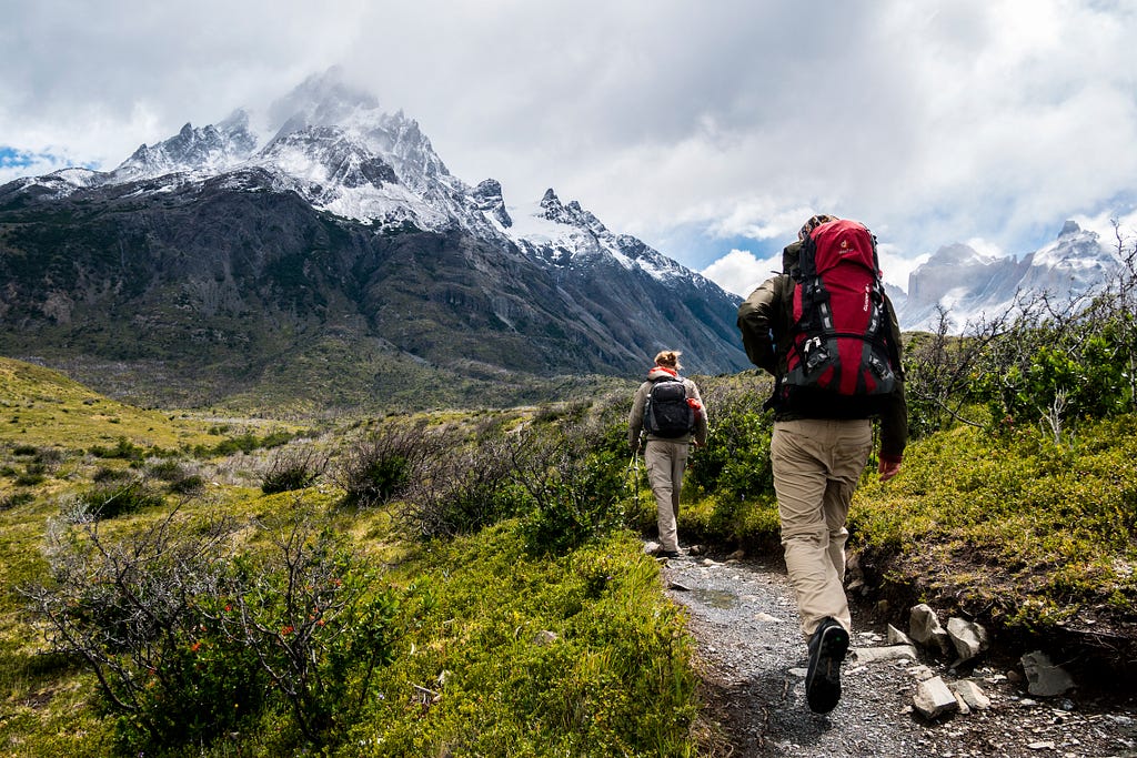 Two hikers head off on adventure down a wilderness trail.