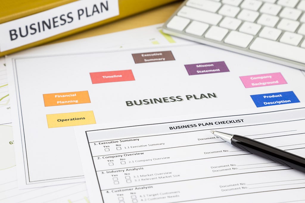 Business plan checklist and paperwork place on office table.