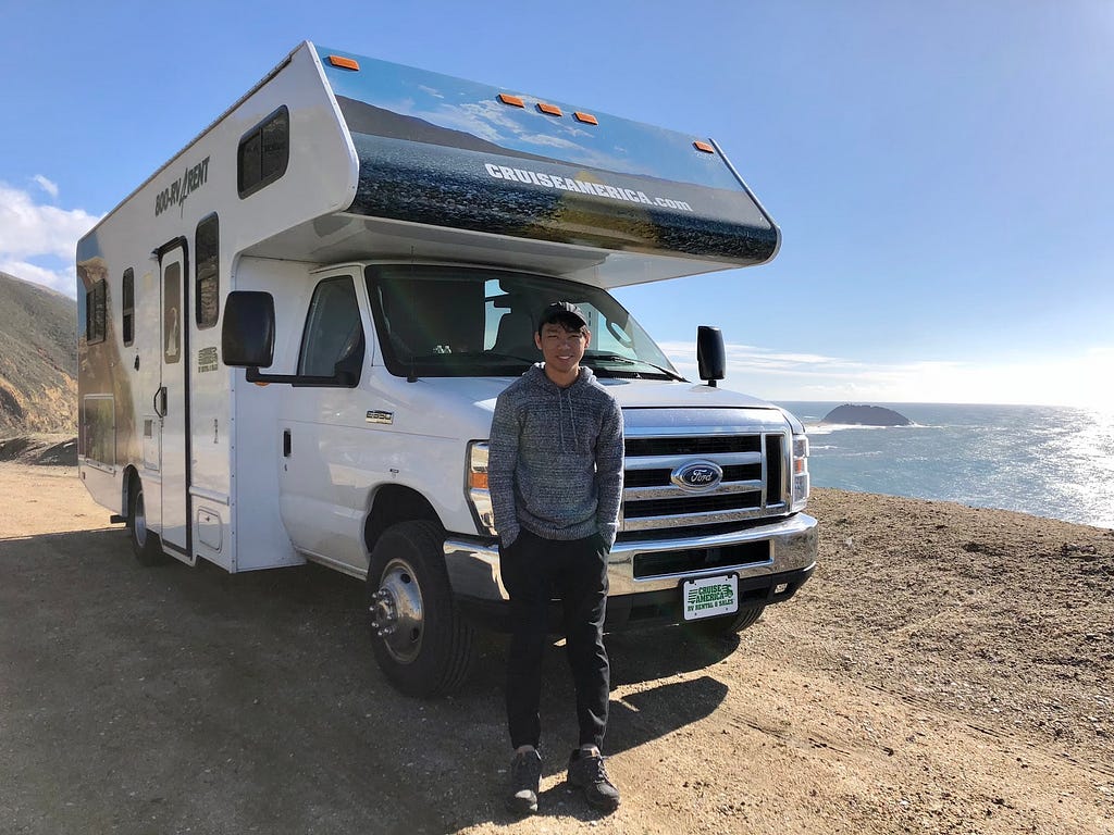 Gabriel Sim standing in front of his truck on the side of the road