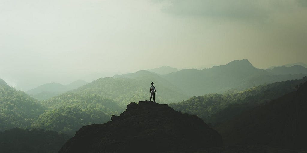 An individual looking beyond mountains