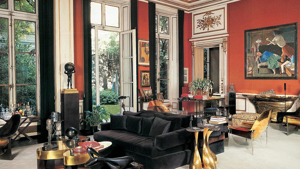 Parisian apartment, the home of Henri Samuel. Features red walls, white coping and door frames, black sofas, gold furnishings and various small sculptures.