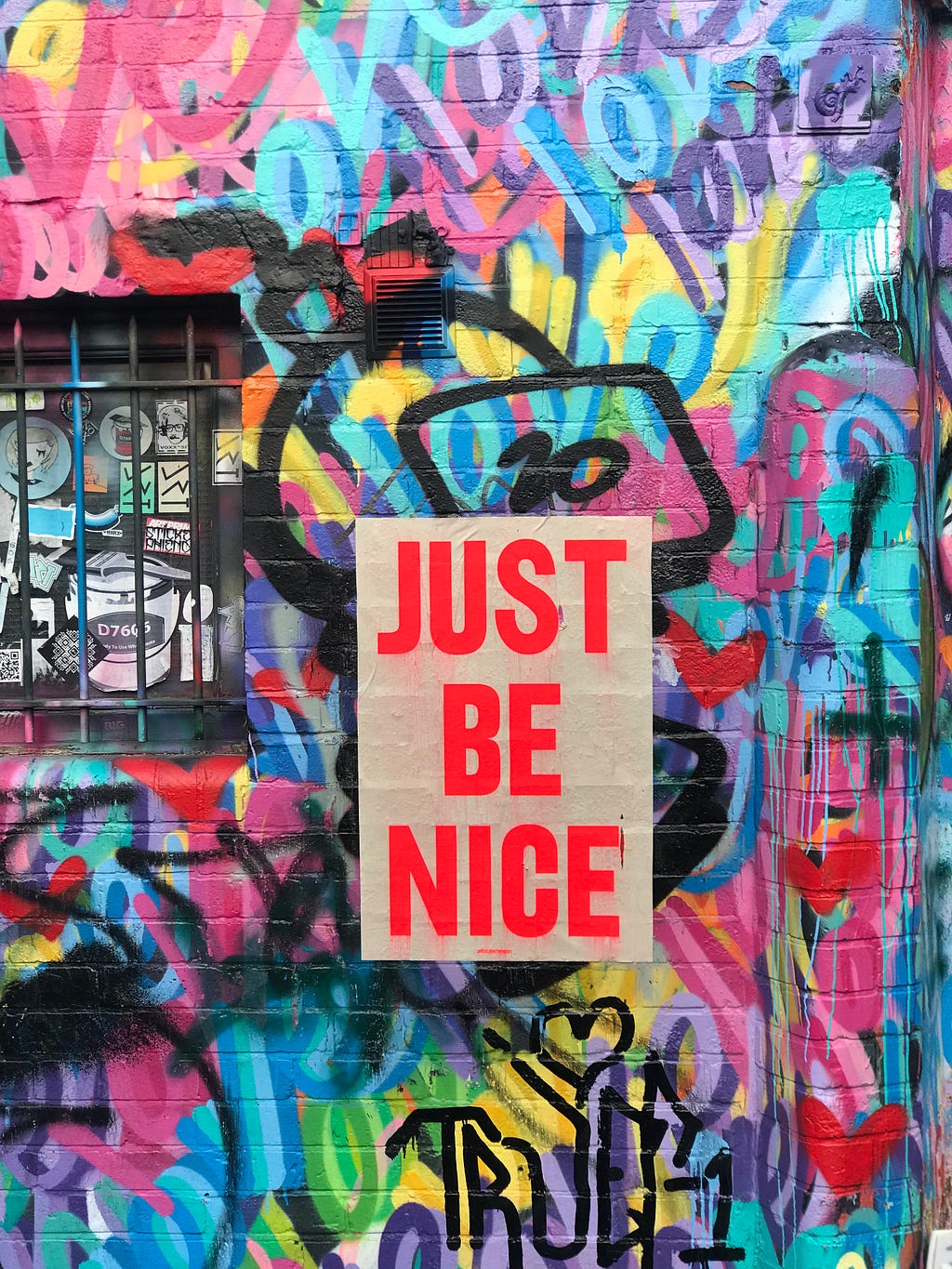 A graffiti wall with the message “just be nice”