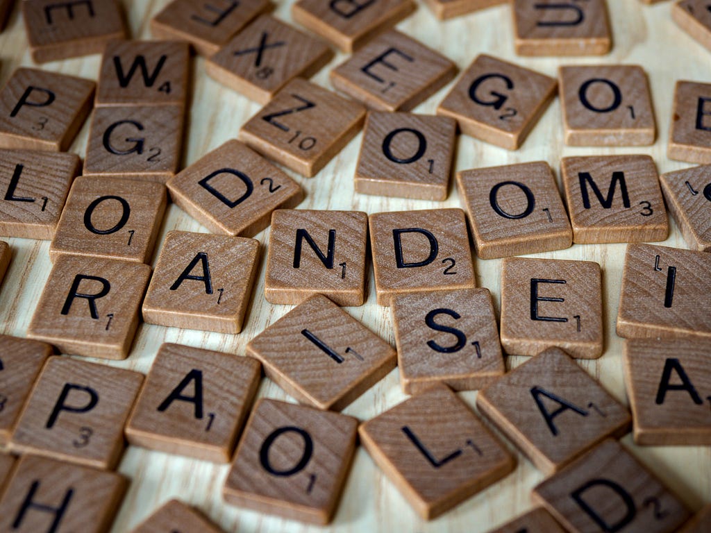 letters on many pieces of wood scattered around on the table