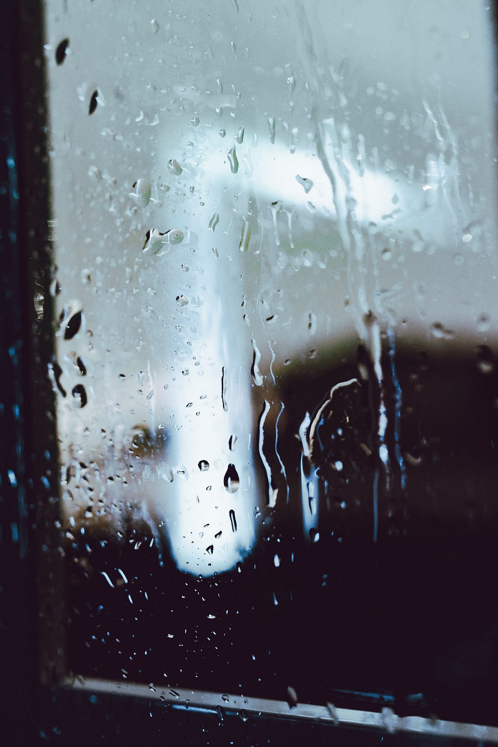 Rain drops streaking down a window.