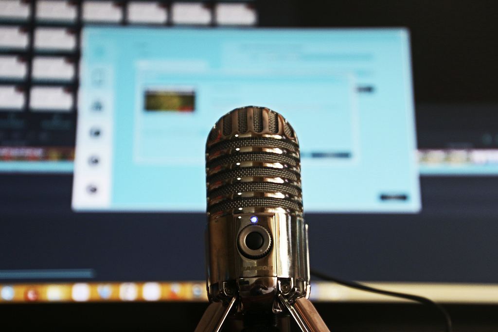 Closeup of a microphone with a computer screen in the background