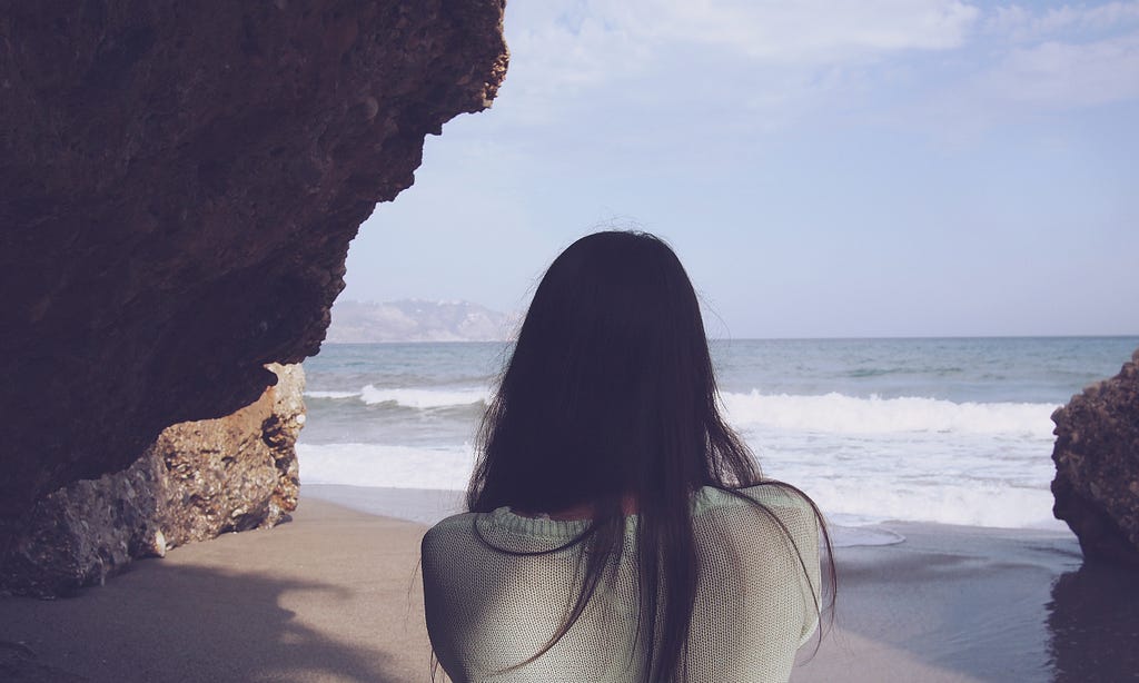 Woman looks out to scenic beach view