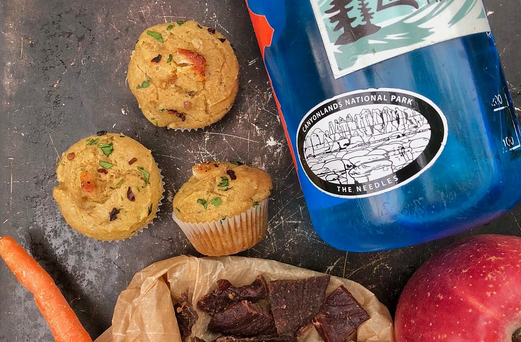 paleo green chili chicken mini snack muffins next to a water bottle and trail snacks