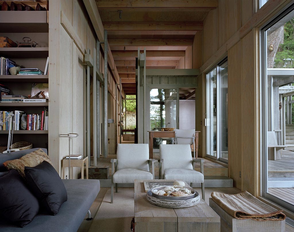 Living Room, Chair, Sofa, Coffee Tables, Medium Hardwood Floor, Rug Floor, Floor Lighting, Shelves, Lamps, and End Tables Materials enhance this natural connection, reflecting the silvery hues of the overcast sky of the Pacific Northwest and tying the building to the forest floor.&nbsp;