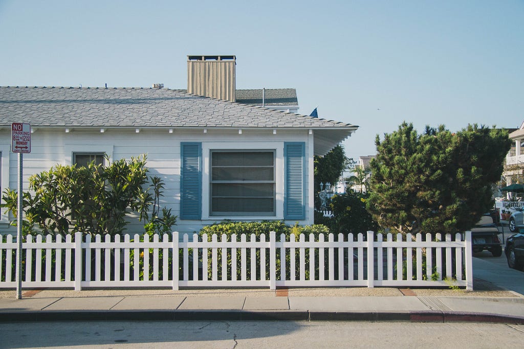 A single-family home with white picket fence