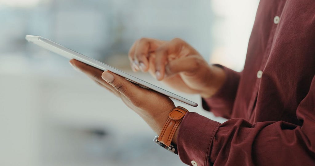 Closeup of man’s hand typing on digital tablet