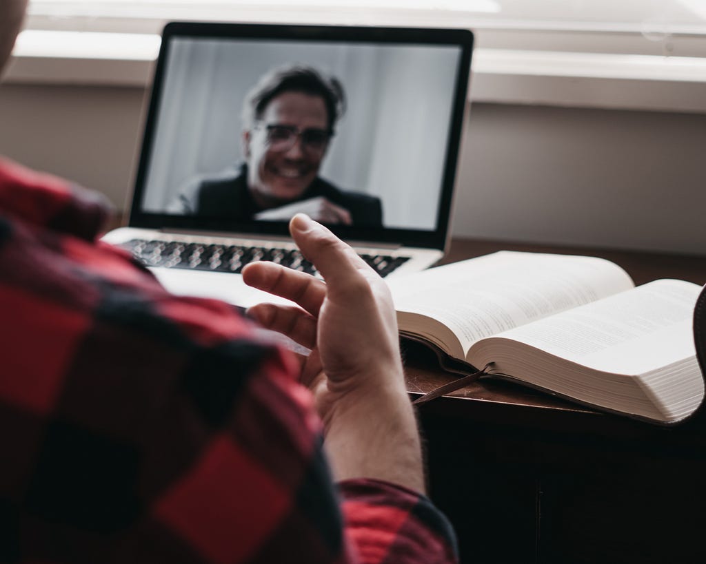 Video call with participant on laptop while notetaking