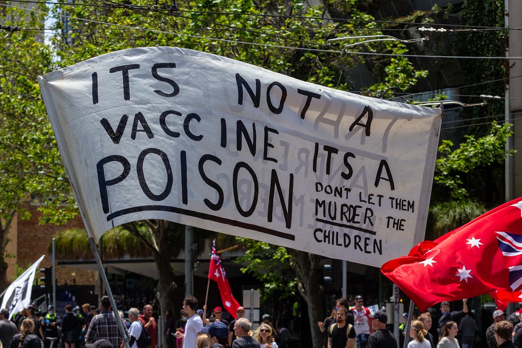 A banner in a protest claiming vaccines are poison