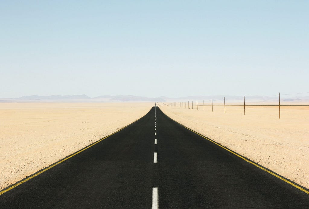 Road in a desert leading off to the far distance, undisturbed by anything. Just like a linear lifepath.