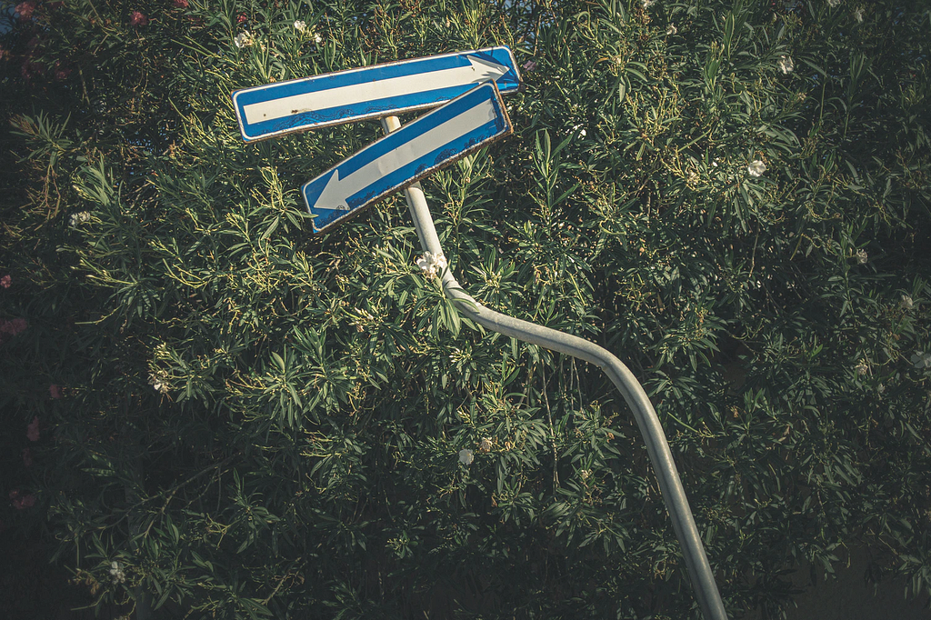 A sign post with arrows pointing in different directions