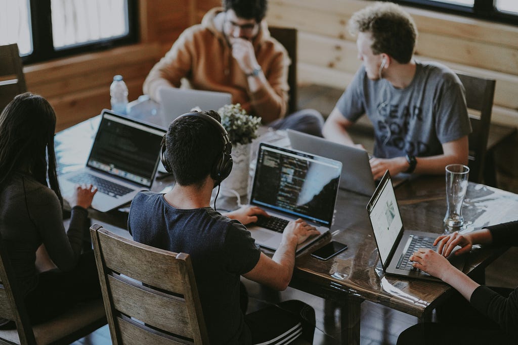 Five people are using laptop for doing their works and assignments.