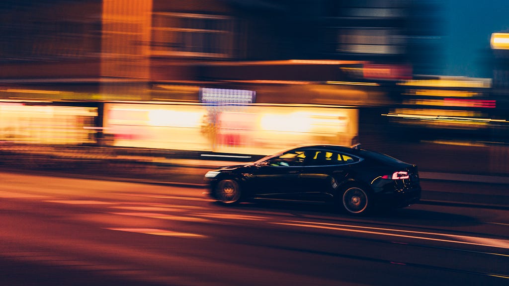 A car driving at a fast speed with background blurred