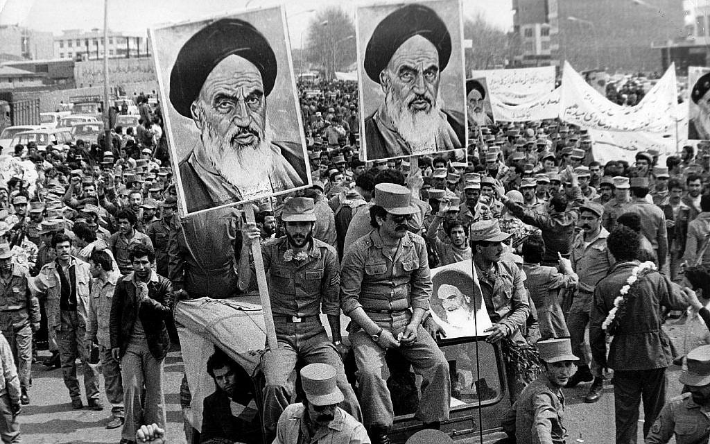 Crowd of Iranian revolutionaries holding portraits of Ayatollah Khomeini during the 1979 Iranian Revolution.