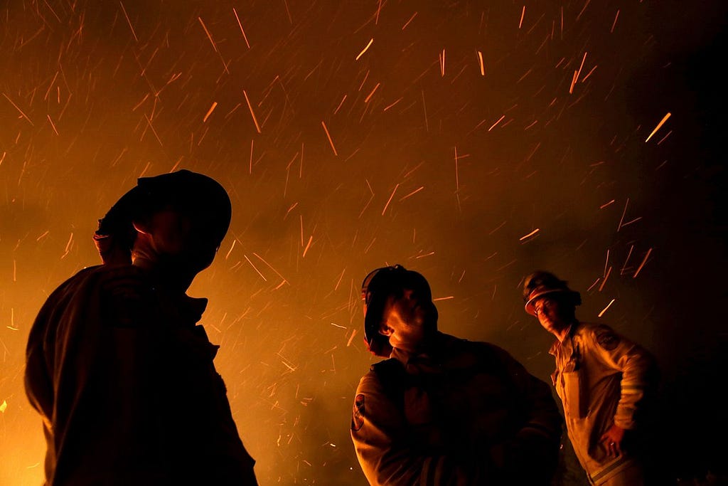 FRESH POND, CA - SEPTEMBER 17: Embers swirl around firefighters as they monitor a backfire while battling the King Fire on September 17, 2014 in Fresh Pond, California. The King fire is threatening over 1,600 homes in the forested area about an hour east of Sacramento and has consumed over 18,544 acres. The out of control fire is 5 percent contained. (Photo by Justin Sullivan/Getty Images)