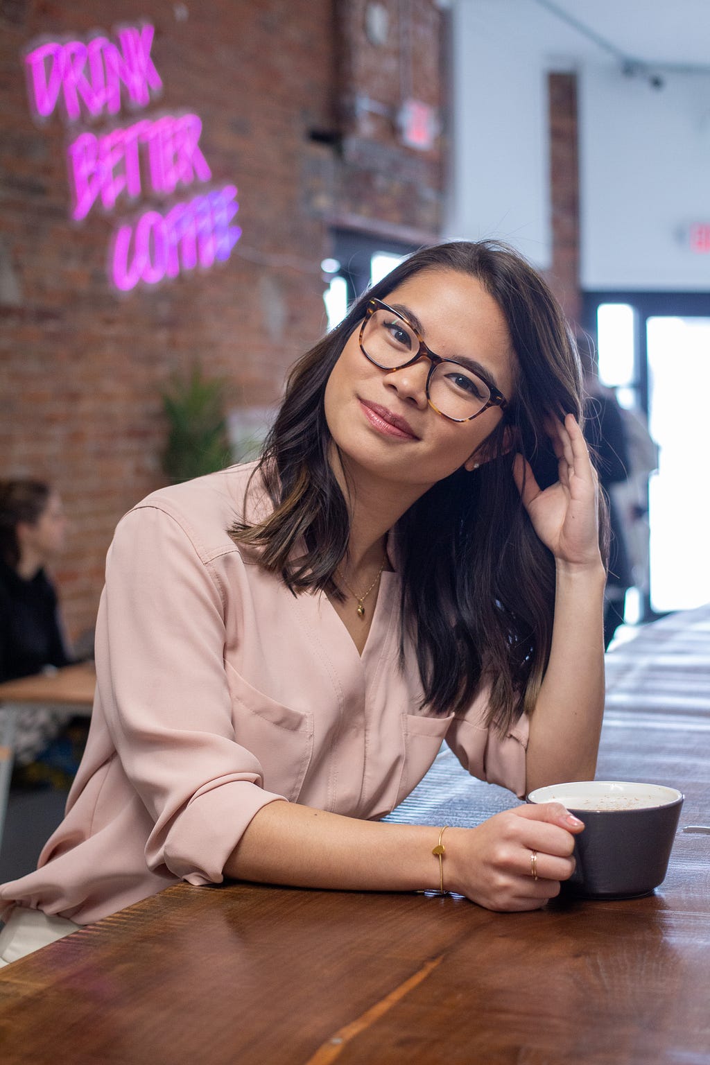 Woman with glasses sitting in a coffee shop.