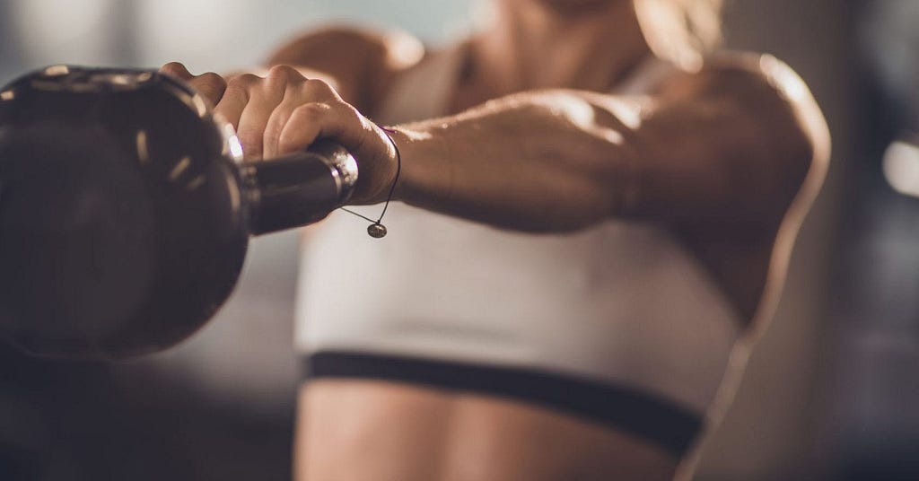 woman swinging kettle bell in resistance training