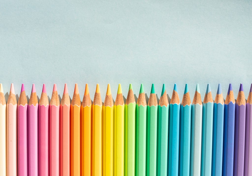 Vários lápis de cor organizados em ordem cromática. do jeito que eu faço desde criança.