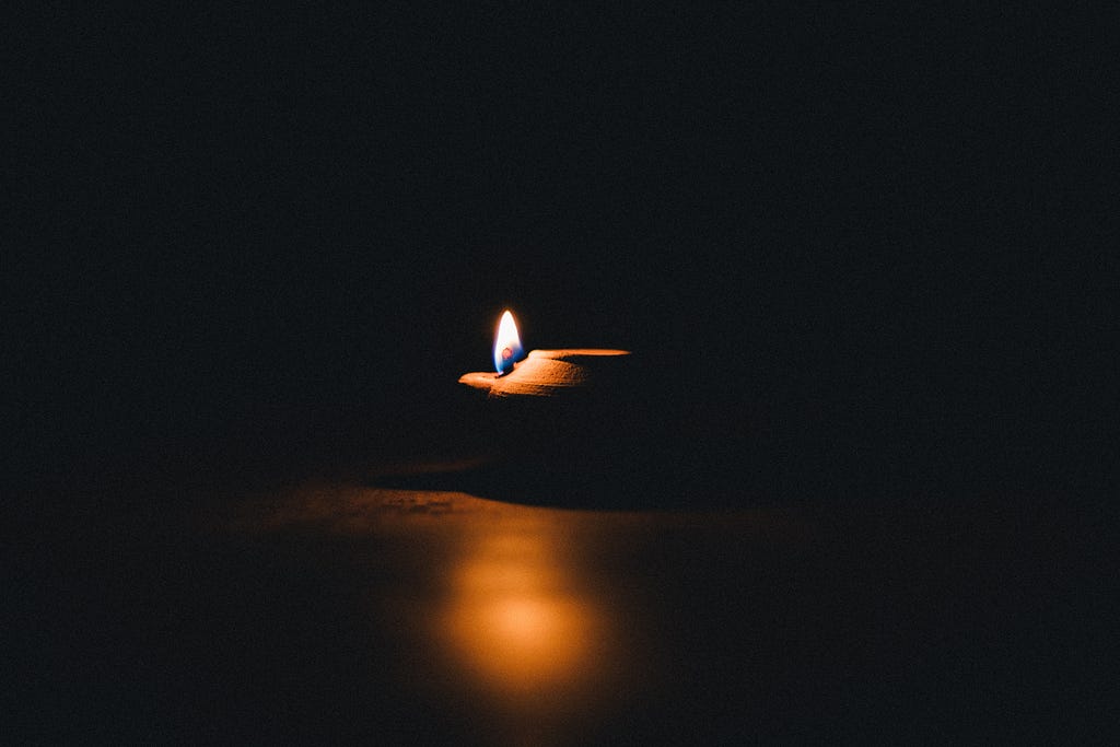 A picture of a flame burning in the darkness.